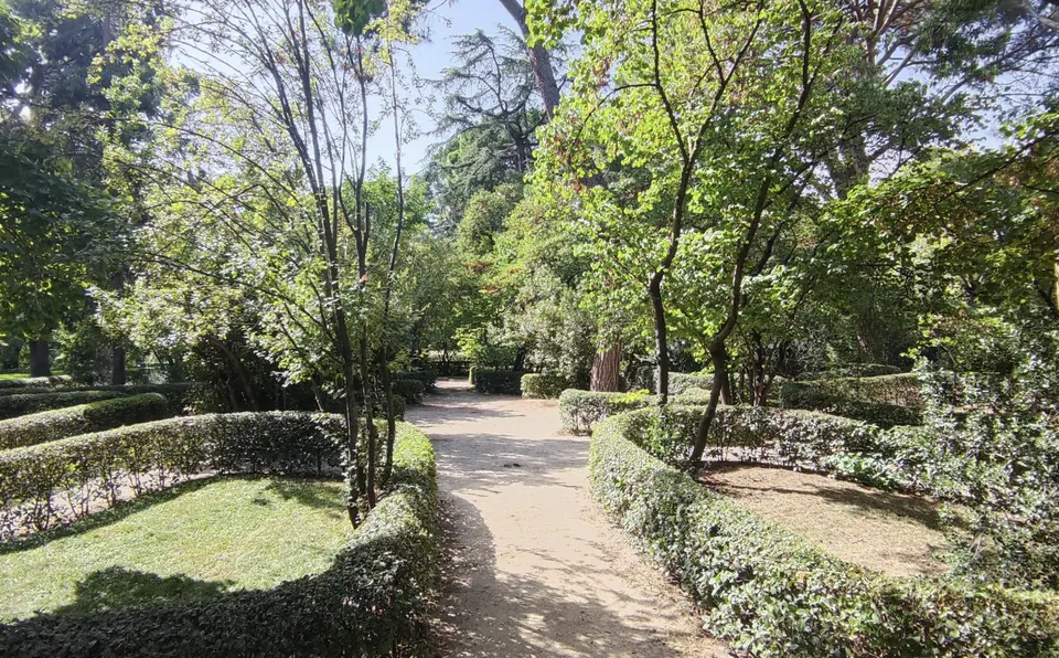 Camino entre setos y árboles del Jardín de Juegos